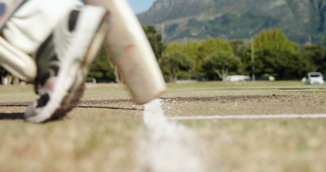 Cricketer Running Mid-Match on Sundrenched Field