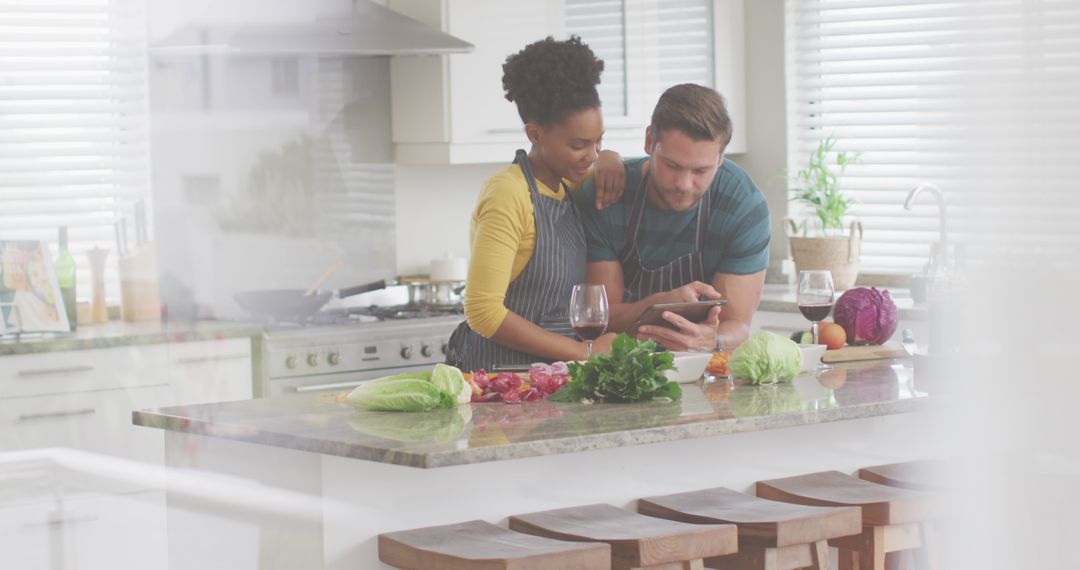 Diverse Couple Cooking Together with Tablet and Wine