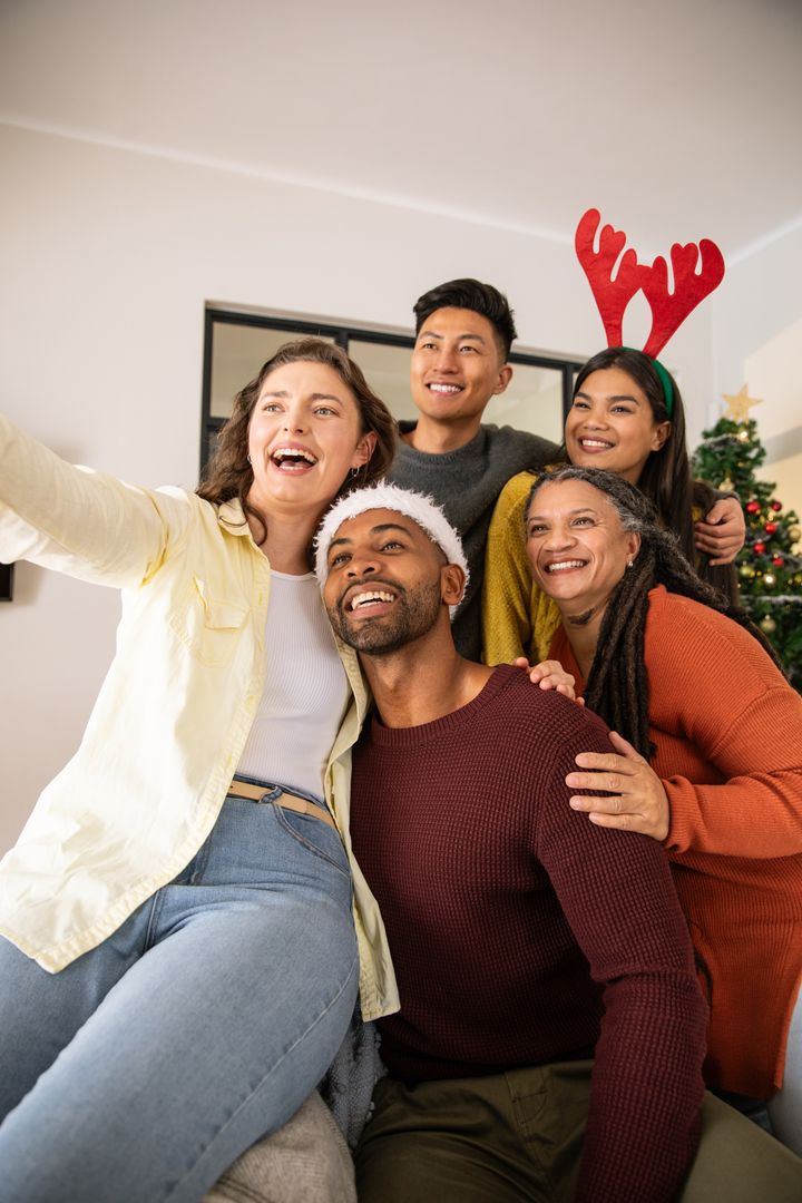 Diverse Friends Celebrating Christmas with Selfie by Festive Tree