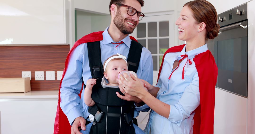 Happy Parents in Red Cloaks Feeding Baby in Modern Kitchen - Free Images, Stock Photos and Pictures on Pikwizard.com