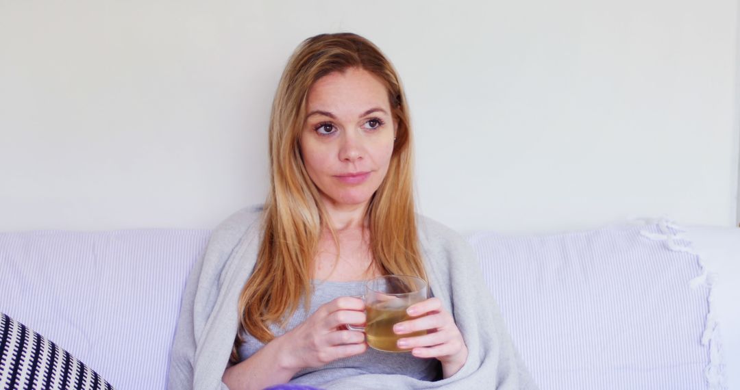 Woman Relaxing on Couch with Cup of Tea - Free Images, Stock Photos and Pictures on Pikwizard.com