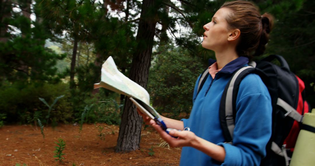 Adventurous Woman Navigating Forest Trail with Map