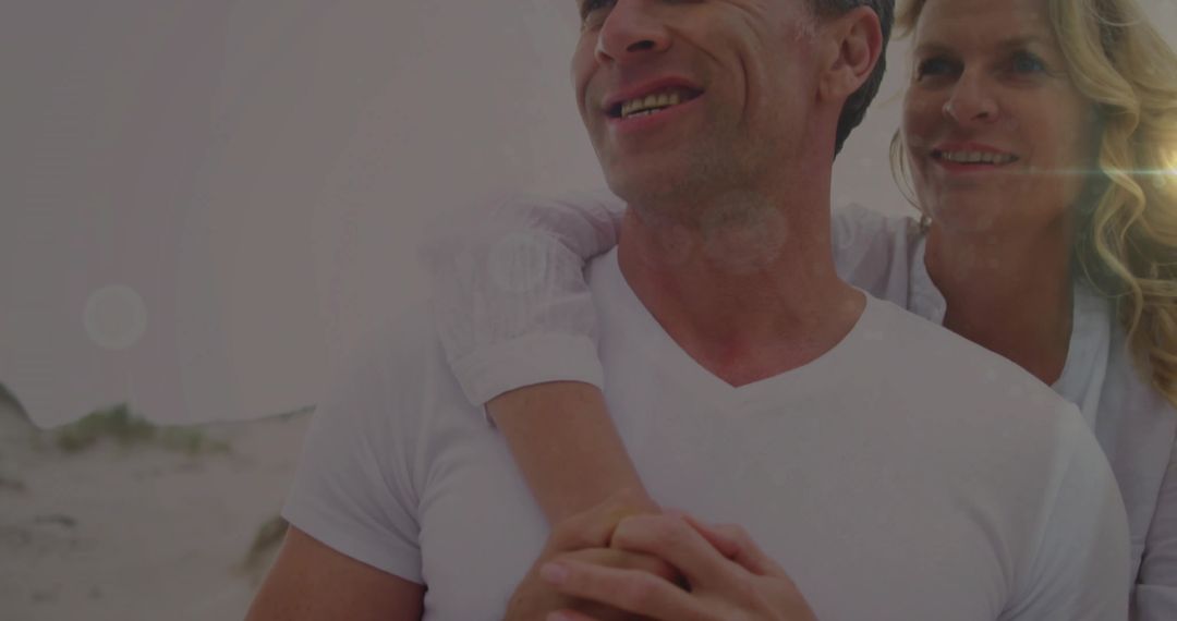 Smiling Mature Couple Embracing on Sandy Beach