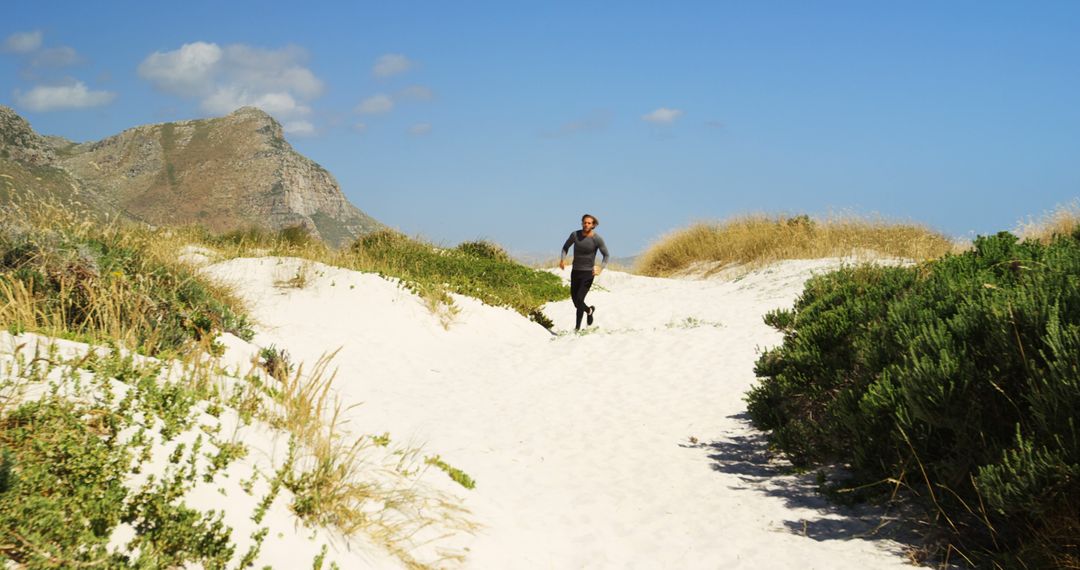 Man Running on Sandy Trail Through Scenic Beach Dunes - Free Images, Stock Photos and Pictures on Pikwizard.com