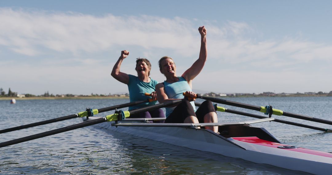 Two Women Celebrating Victory in Rowboat on Sunny Day - Free Images, Stock Photos and Pictures on Pikwizard.com