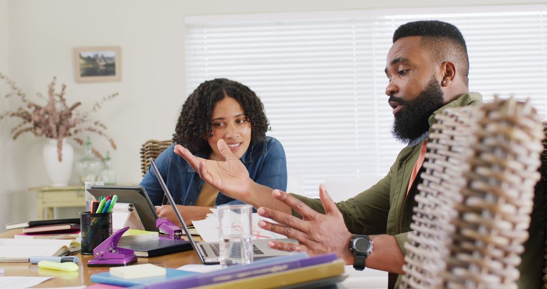 Diverse Friends Collaborating on Project with Laptop at Home
