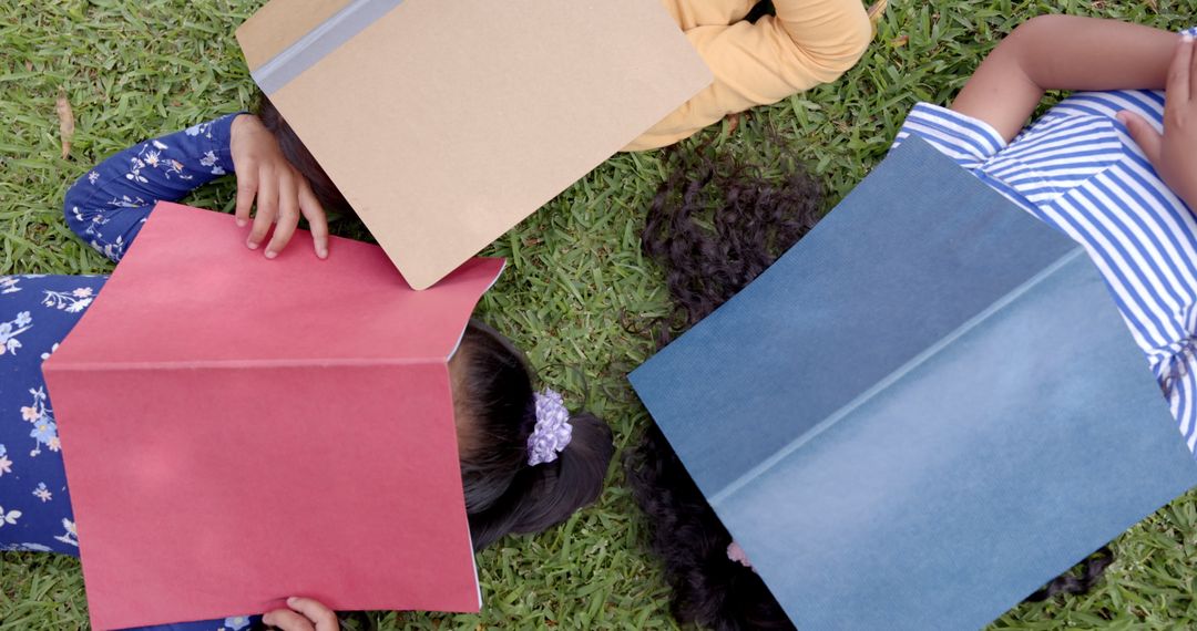Girlfriends Relaxing Together on Grass with Books