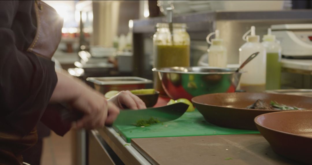 Professional Chef Chopping Herbs in Busy Culinary Kitchen