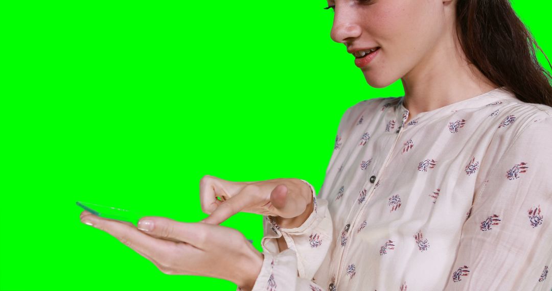 Woman pretending to hold digital tablet against green screen - Free Images, Stock Photos and Pictures on Pikwizard.com
