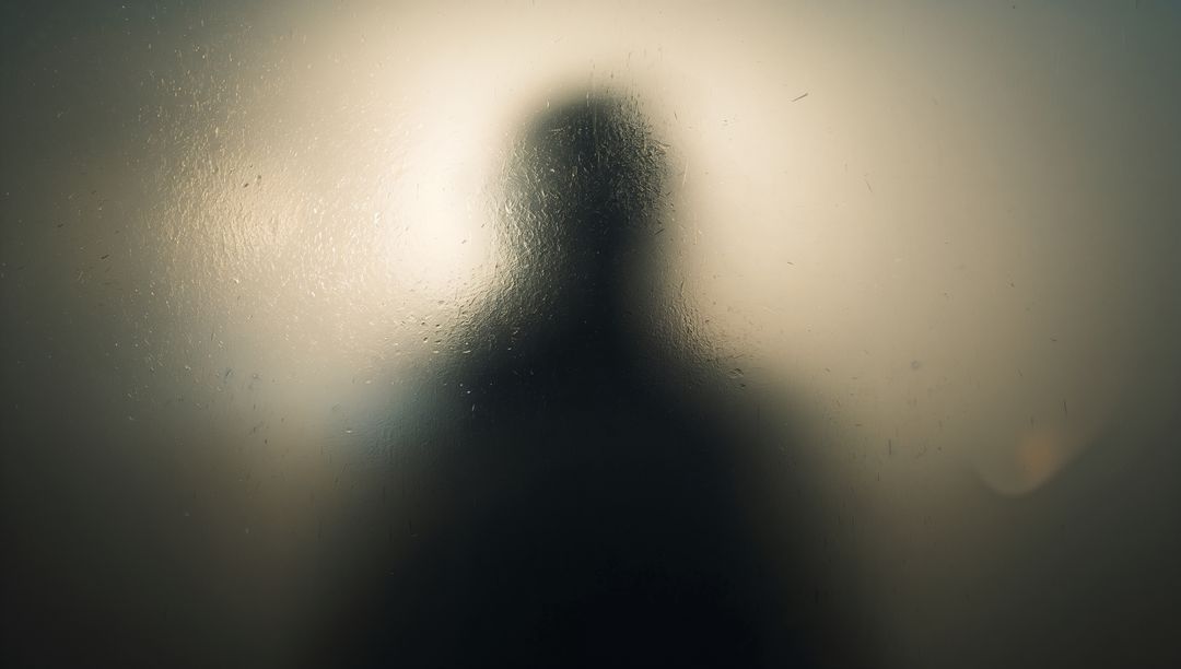 Mysterious Silhouette Behind Steamy Glass: Intriguing Privacy Concept