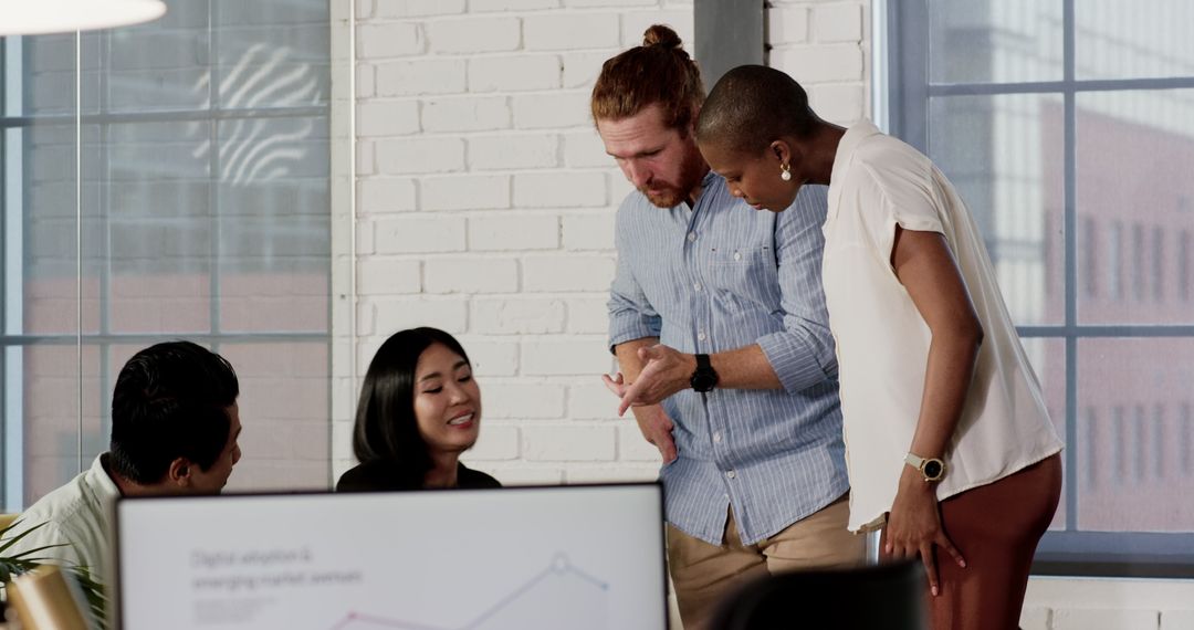 Diverse Team Collaborating Over Digital Projects in Modern Office
