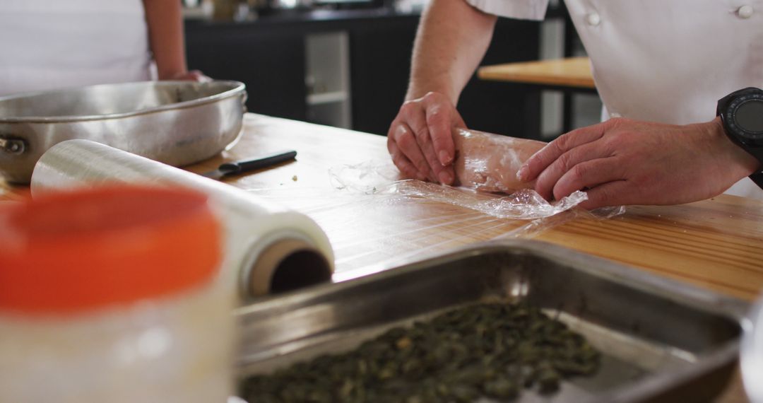 Chef preparing food with plastic wrap in professional kitchen - Free Images, Stock Photos and Pictures on Pikwizard.com