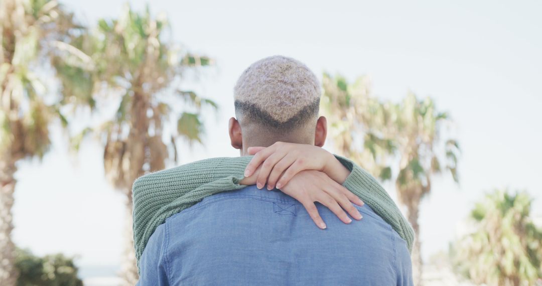 Couple embracing outdoors with palm trees in background - Free Images, Stock Photos and Pictures on Pikwizard.com