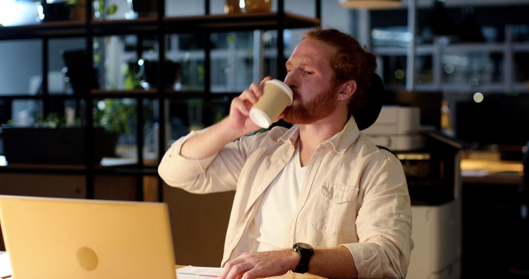 Red-Haired Professional Drinking Coffee While Working Late
