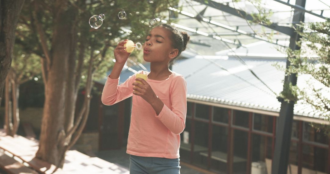 Child Joyously Blowing Soap Bubbles Outdoors