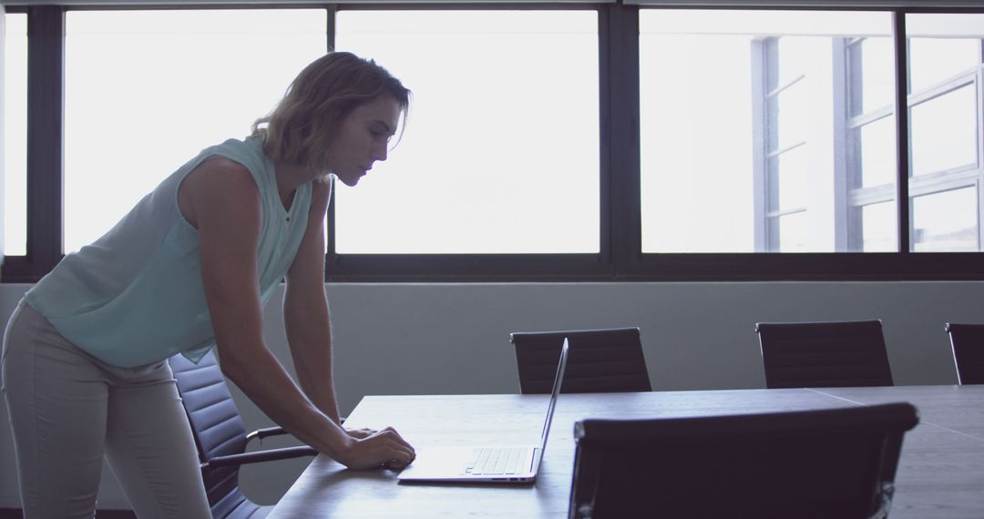 Focused Businesswoman Using Laptop in Modern Office Environment