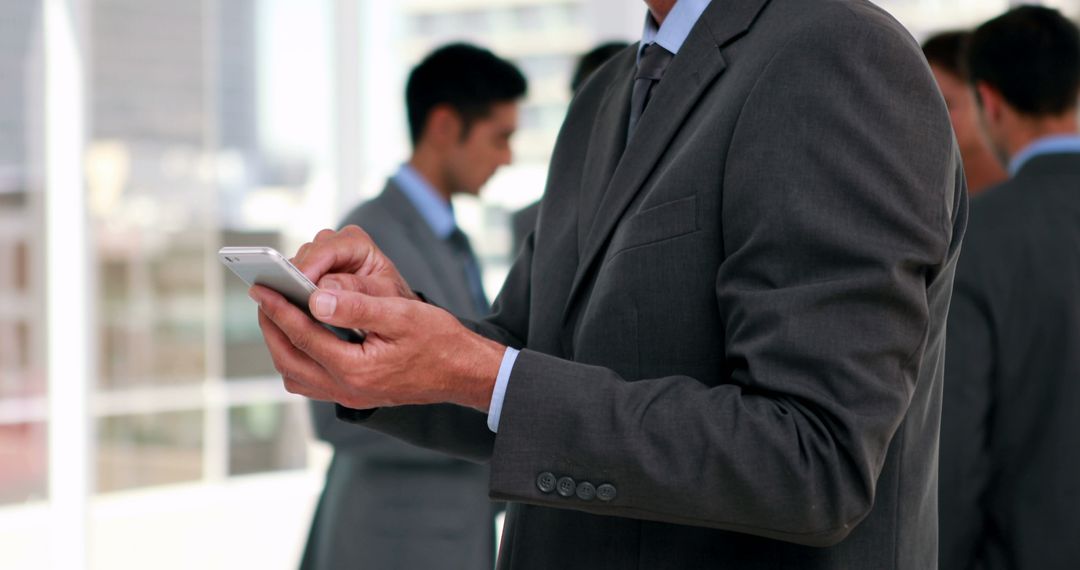 Businessman Using Smartphone in Office Setting - Free Images, Stock Photos and Pictures on Pikwizard.com