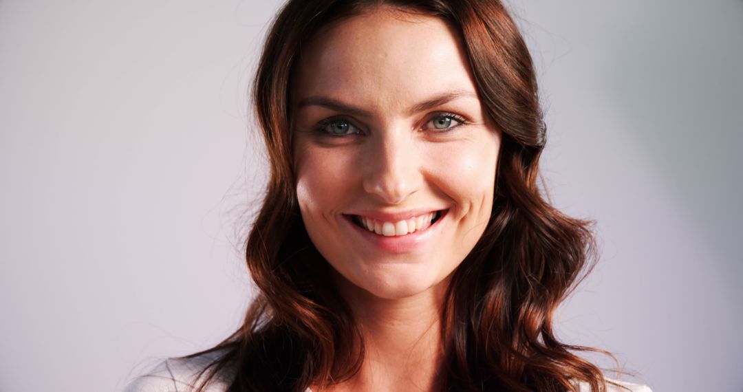 Smiling Woman with Wavy Hair in Studio Portrait - Free Images, Stock Photos and Pictures on Pikwizard.com