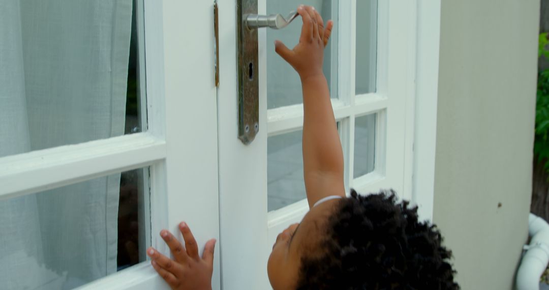 Curious Child Reaching Central Door Handle at Home - Free Images, Stock Photos and Pictures on Pikwizard.com