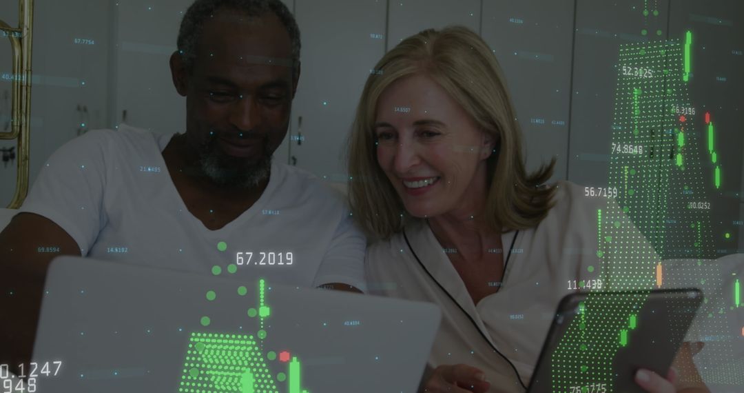 Diverse Couple Analyzing Financial Data on Laptop and Tablet