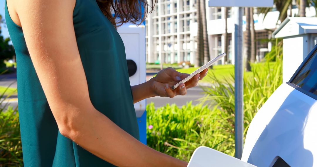 Woman Using Smartphone While Charging Electric Car Outdoors - Free Images, Stock Photos and Pictures on Pikwizard.com