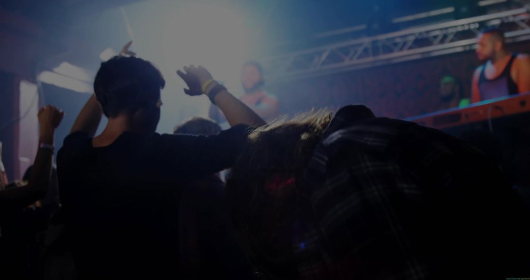 Energetic Crowd Dancing at Nightclub Music Event