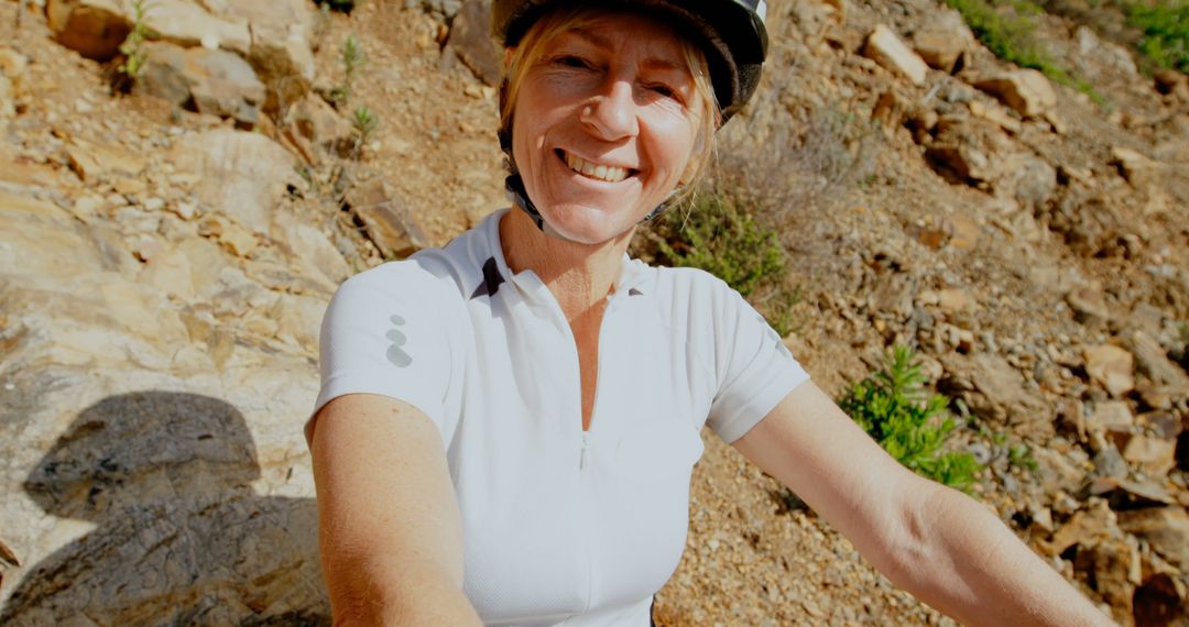 Smiling Woman Wearing Helmet and Cycling Jersey on Rocky Path - Free Images, Stock Photos and Pictures on Pikwizard.com