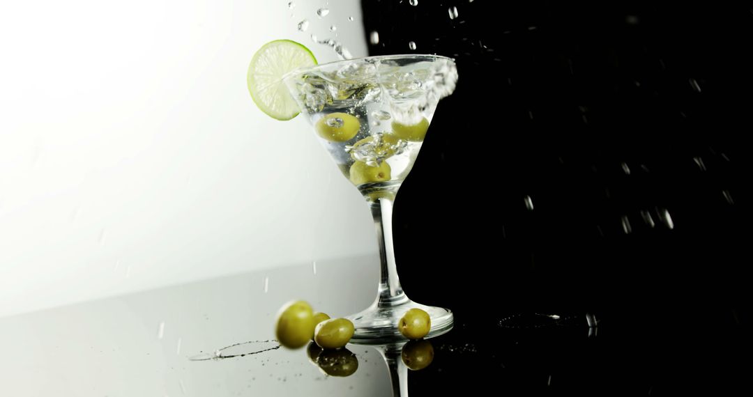 Martini Splashing with Olives and Lime Garnish - Free Images, Stock Photos and Pictures on Pikwizard.com