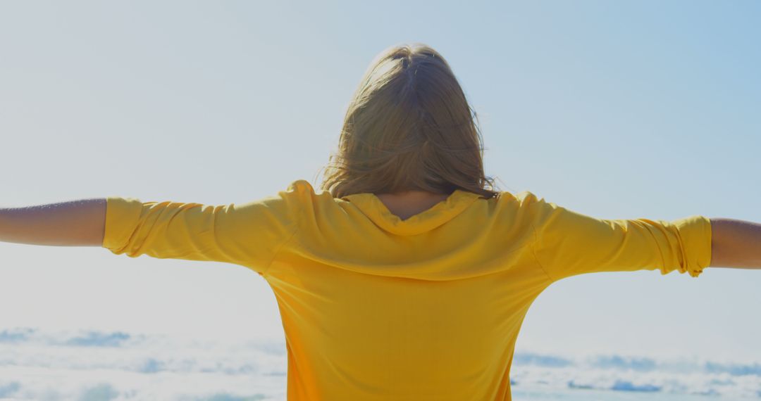 Woman in Yellow Top Enjoying Sea Breeze with Open Arms - Free Images, Stock Photos and Pictures on Pikwizard.com