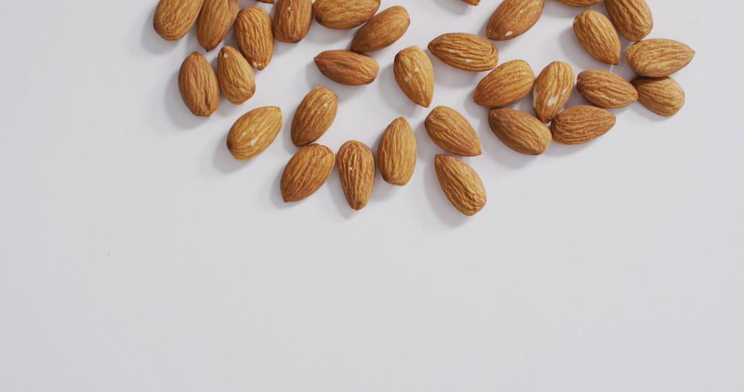 Almonds Scattered on White Surface for Healthy Eating and Vegan Diet