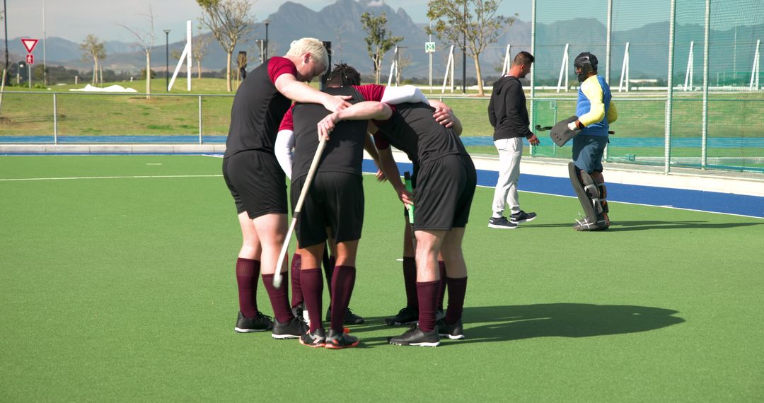 Field Hockey Team Huddling on Artificial Turf Before Match