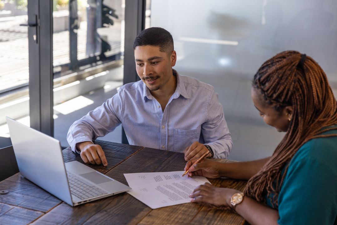 Diverse Professionals Collaborating on Business Documents in Modern Office