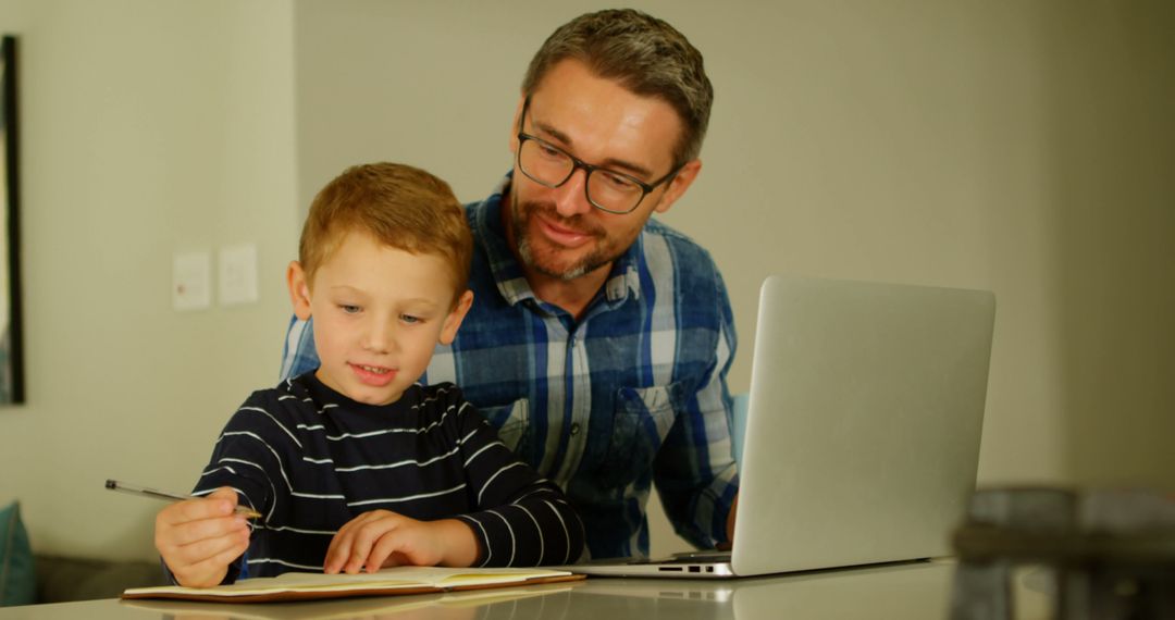 Father and Son Working Together on Homework at Home - Free Images, Stock Photos and Pictures on Pikwizard.com