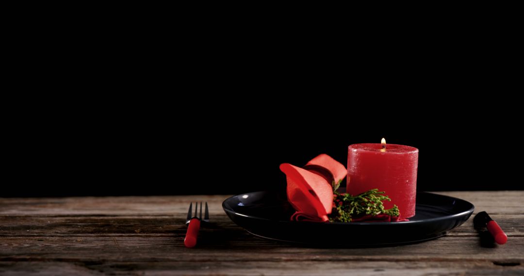 Romantic Table Setting with Red Candle, Rose Petals, and Black Plate - Free Images, Stock Photos and Pictures on Pikwizard.com