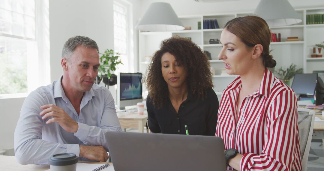 Diverse Business Team Collaborating on Laptop Project in Office