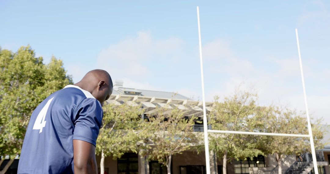 Rugby player standing by goal posts wearing number 4 jersey during practice