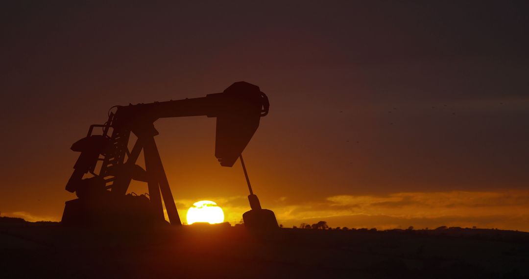 Oil Pump Silhouette at Sunset over Rolling Hills - Free Images, Stock Photos and Pictures on Pikwizard.com