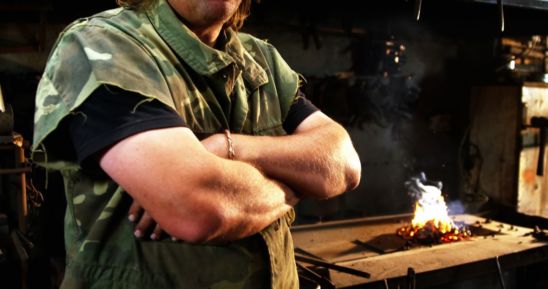 Confident Blacksmith Standing with Arms Folded in Workshop - Free Images, Stock Photos and Pictures on Pikwizard.com