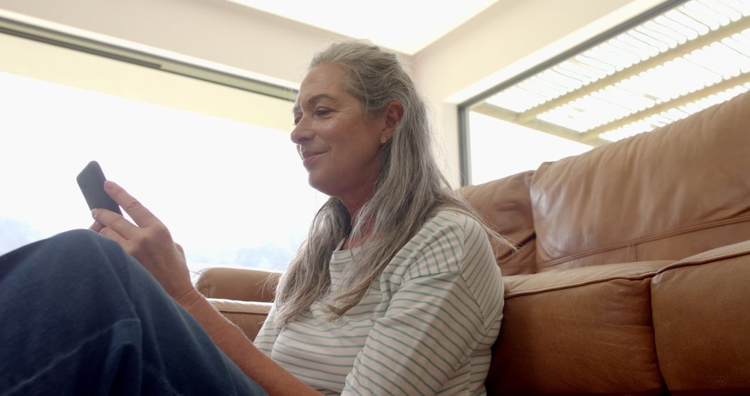 Caucasian Mature Woman Relaxing and Using Smartphone at Home