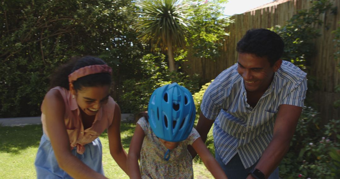 Family Bonding While Teaching Child to Ride Bicycle on Sunny Day