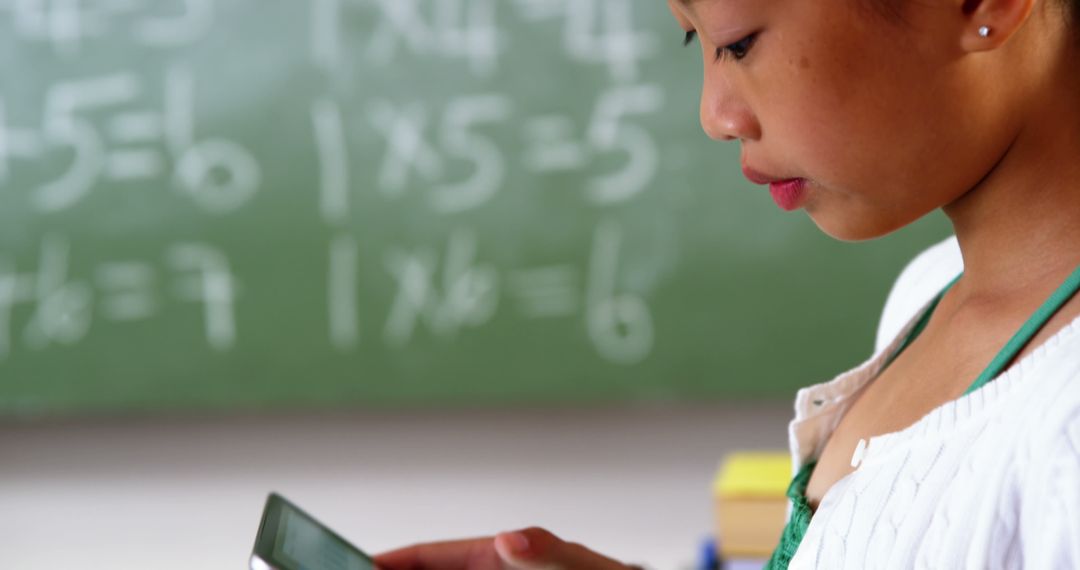 Young Student Using Smartphone in Classroom by Blackboard with Math Equations - Free Images, Stock Photos and Pictures on Pikwizard.com