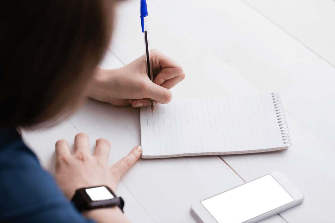 Transparent View of Woman Writing Notes at Workspace