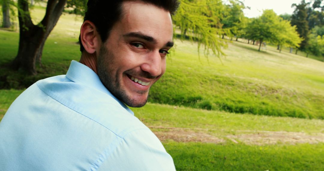 Young Man in Blue Shirt Smiling in Park - Free Images, Stock Photos and Pictures on Pikwizard.com