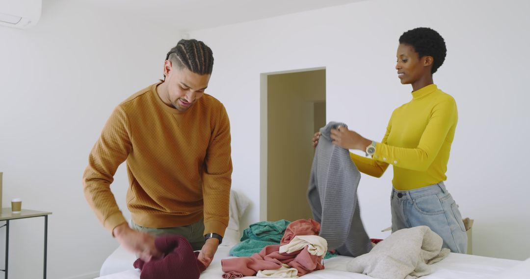 Diverse Couple Folding Laundry in Modern Workspace