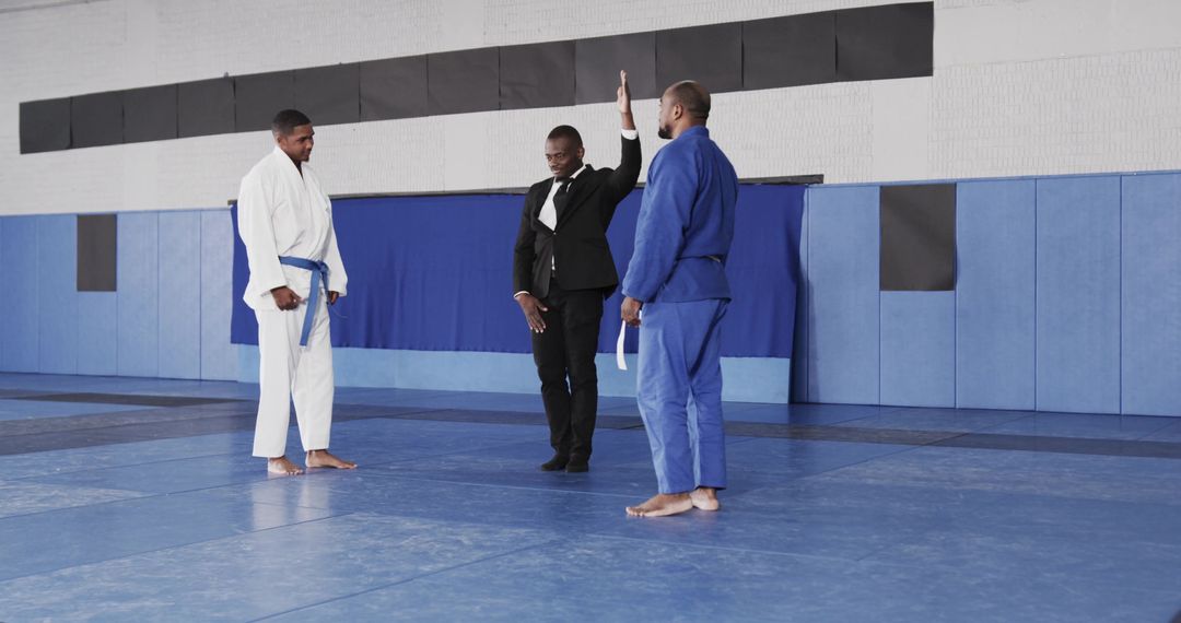 Diverse Martial Arts Competitors Instructed by Referee in Dojo