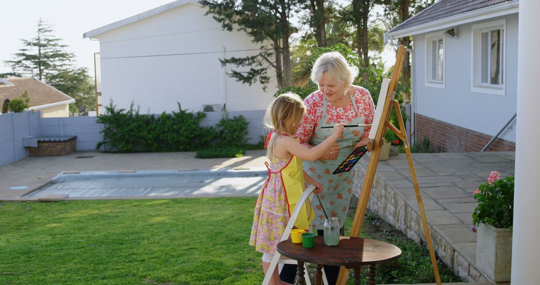 Grandmother and Granddaughter Painting Together Outdoors - Free Images, Stock Photos and Pictures on Pikwizard.com