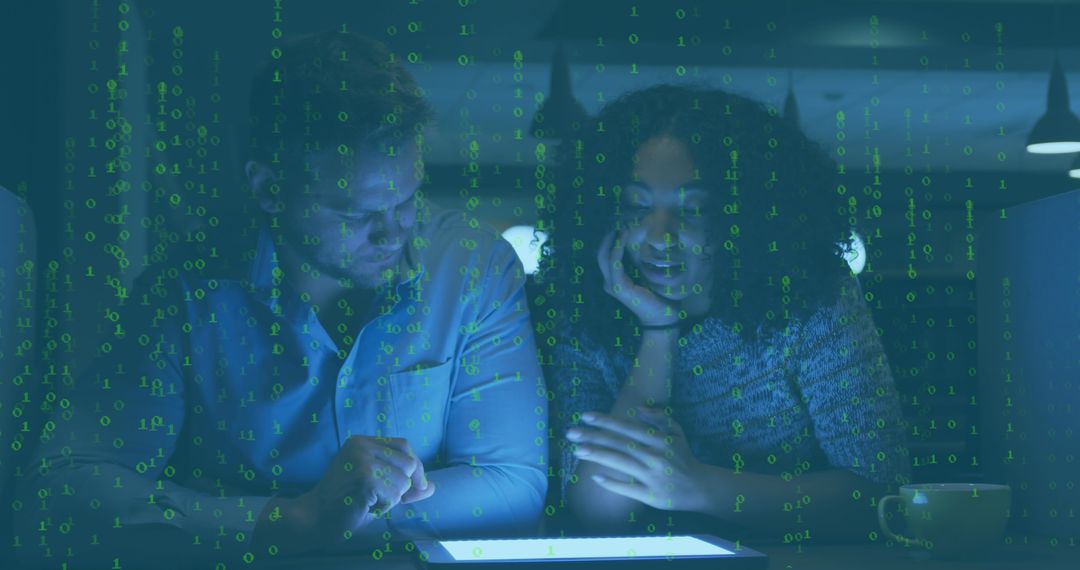 Colleagues Analyzing Data on Digital Tablet in Dimly Lit Office