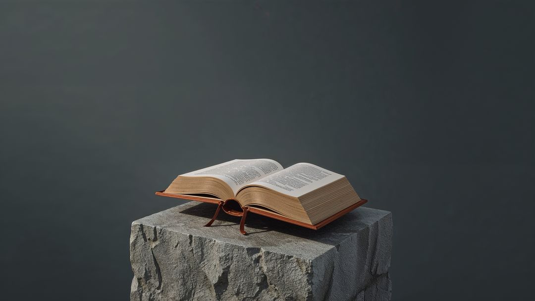 Open Hardcover Book on Stone Pedestal in a Studio Setting