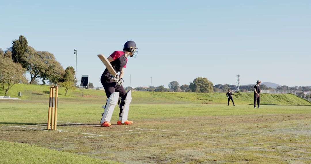 Cricket Match Action Shot on Green Field with Bat and Wicket Stumps