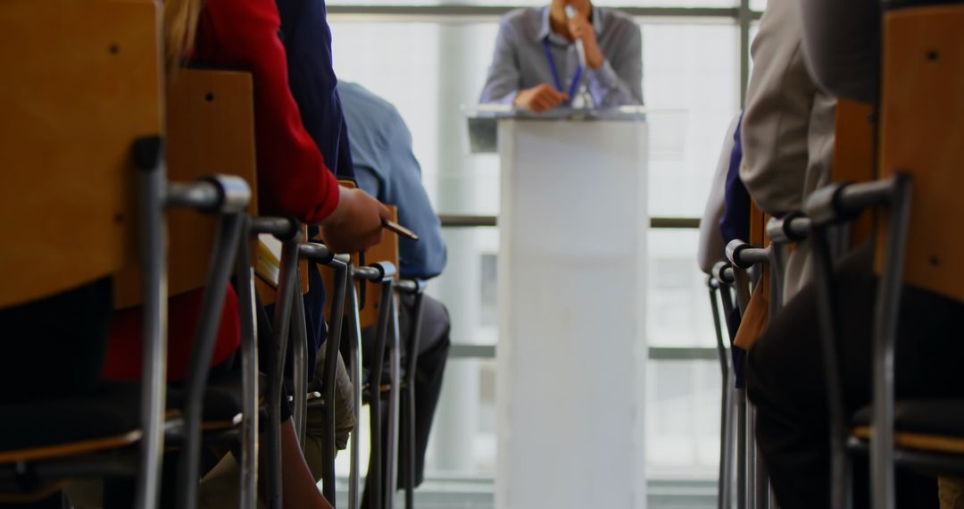 Business Seminar Speaker on Podium Addressing Audience